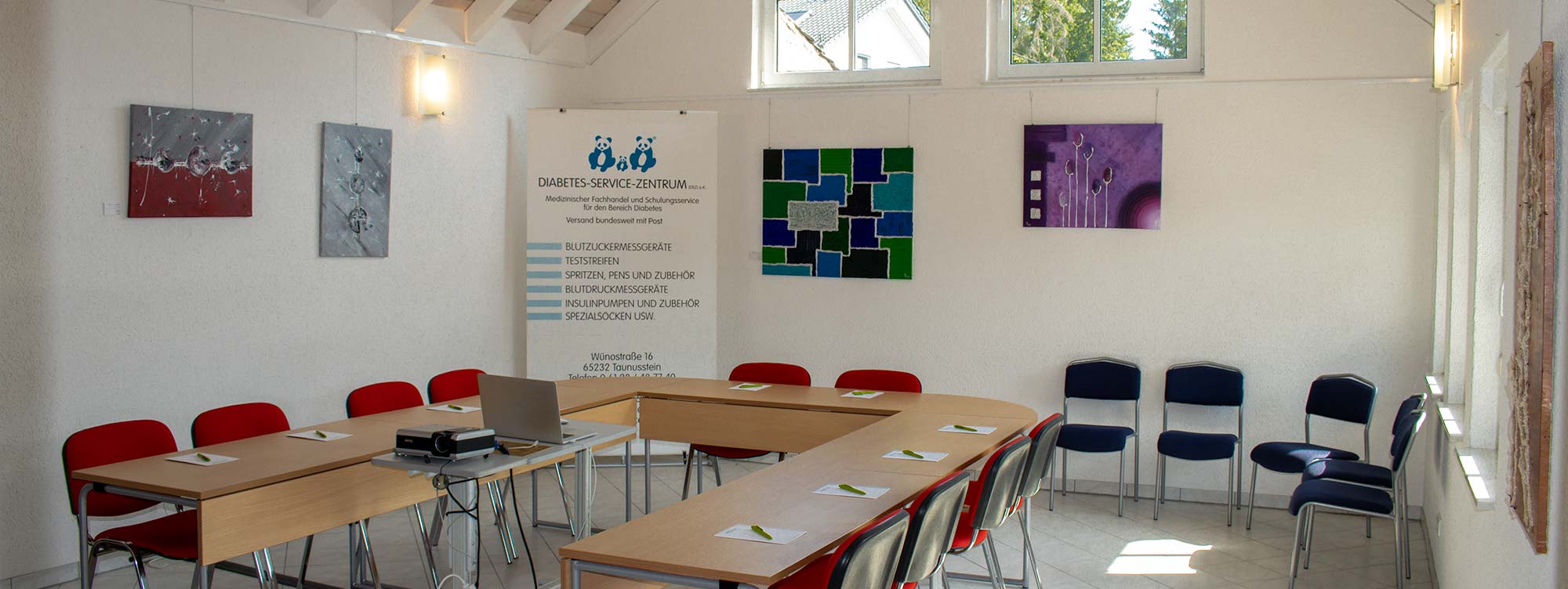 Licht durchfluteter Schulungsraum mit einer Anordnung von Tischen in U-Form und Stühlen.